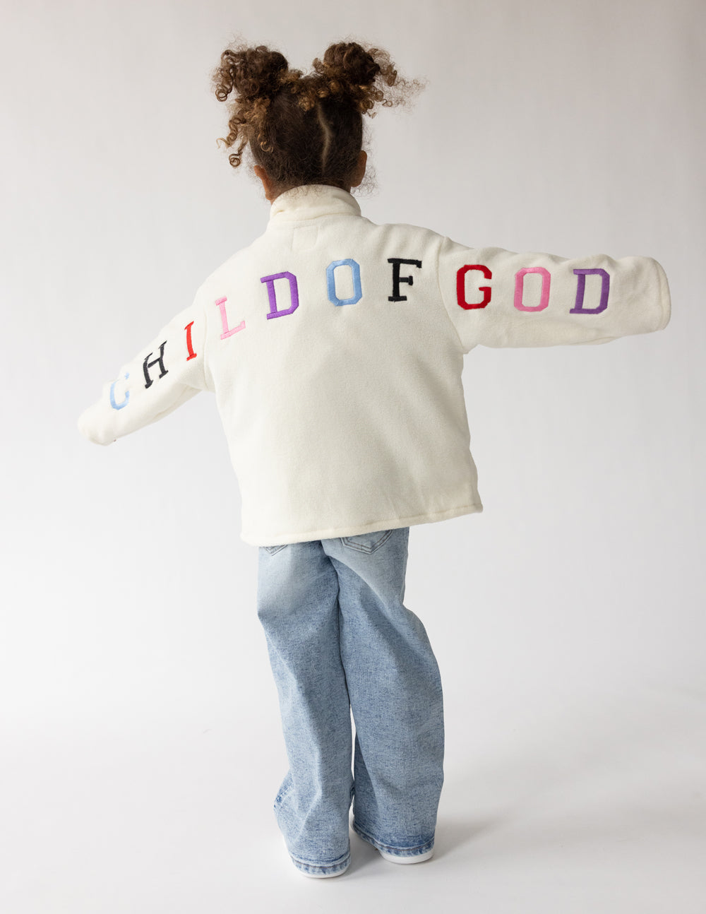Cream Child of God fleece kids pullover with oversized fit and embroidered details for warmth and comfort