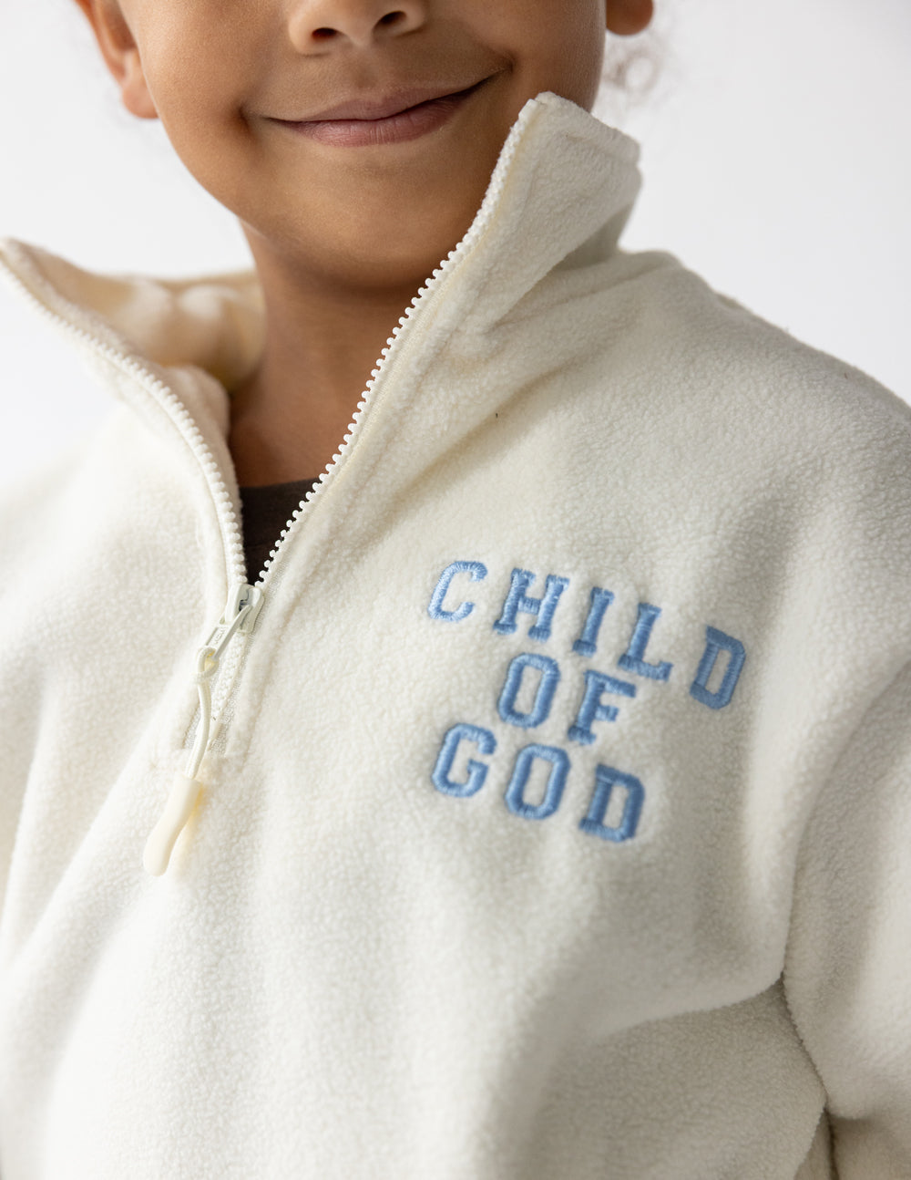 Child of God fleece kids pullover in cream with embroidered faith design and oversized fit