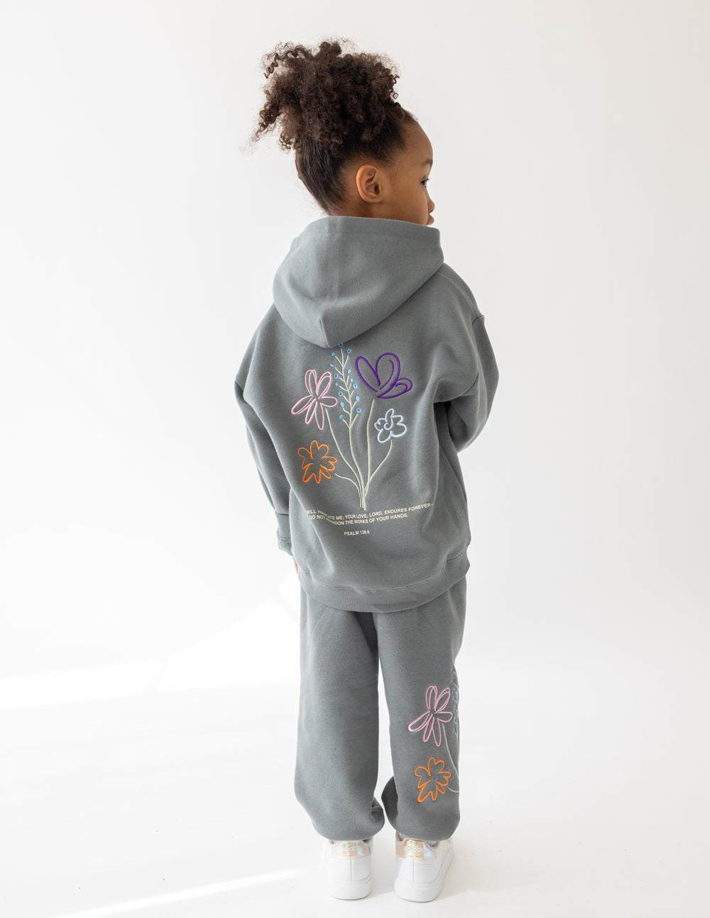 Kids wearing God's Still Working oversized hoodie in Sedona Sage with Psalm 138:8 embroidery