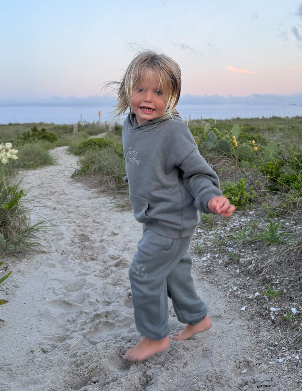 Kids wearing oversized Sedona Sage God's Still Working hoodie with Psalm 138:8 embroidery