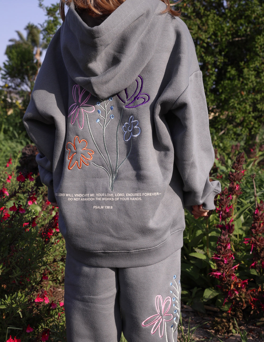 Kids wearing God's Still Working oversized hoodies in Sedona Sage with Psalm 138:8 embroidery