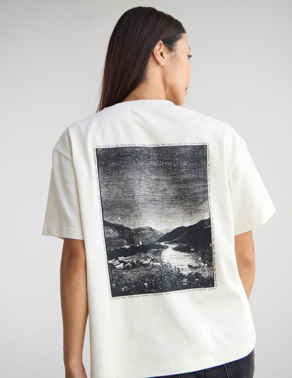 Person wearing almond Psalm 23 unisex tee with oversized fit and Psalm 23:1b scripture design