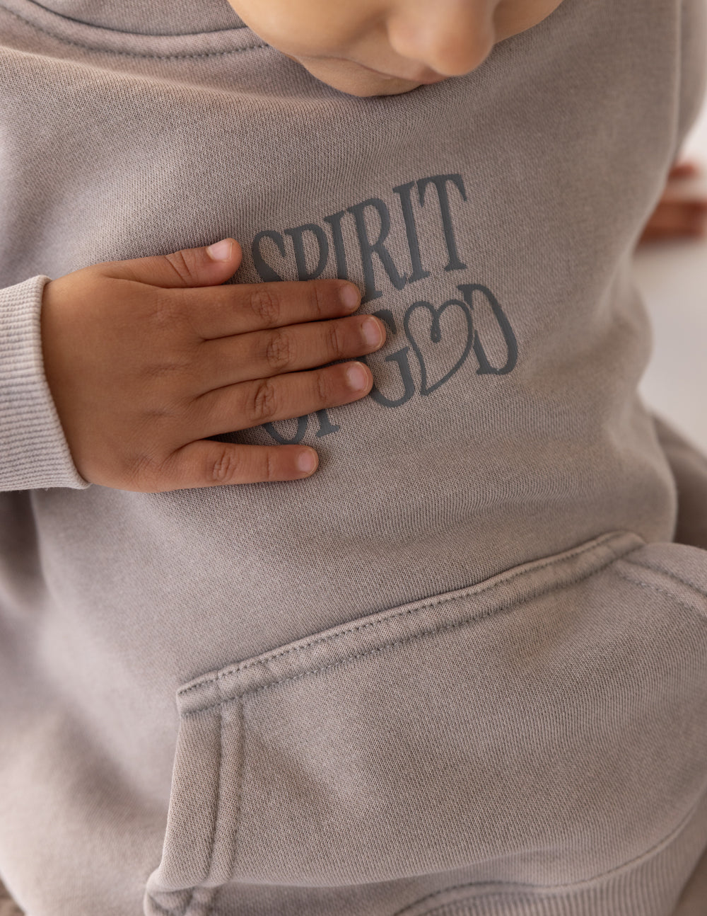 Child wearing oversized Spirit of God Kids Hoodie in echo color, soft cotton blend fabric with biblical print