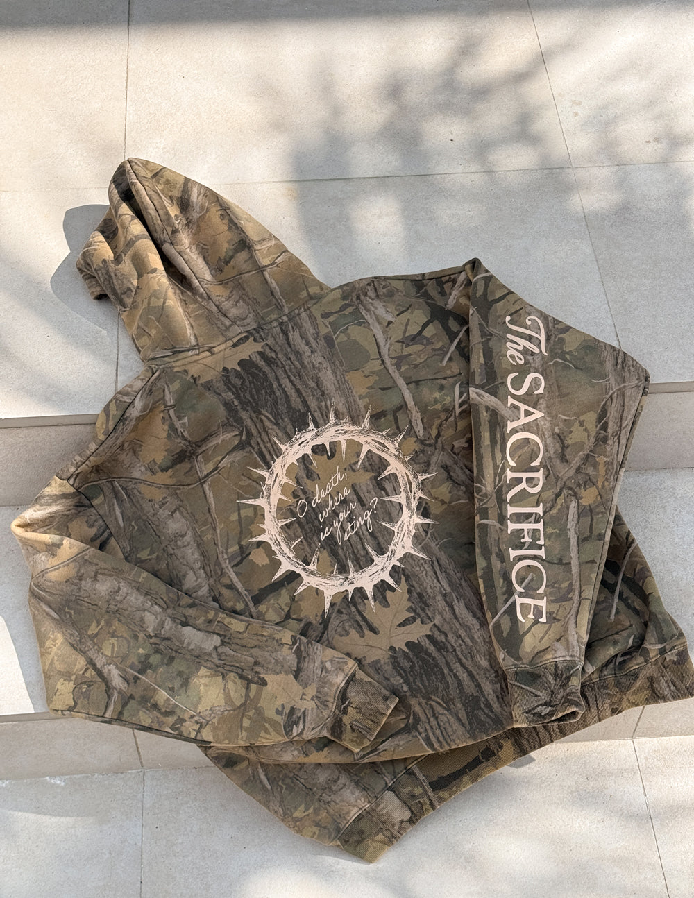 The Sacrifice Camo Hoodie unisex forest camo garment dyed hoodie with 1 Corinthians 15:55 scripture print