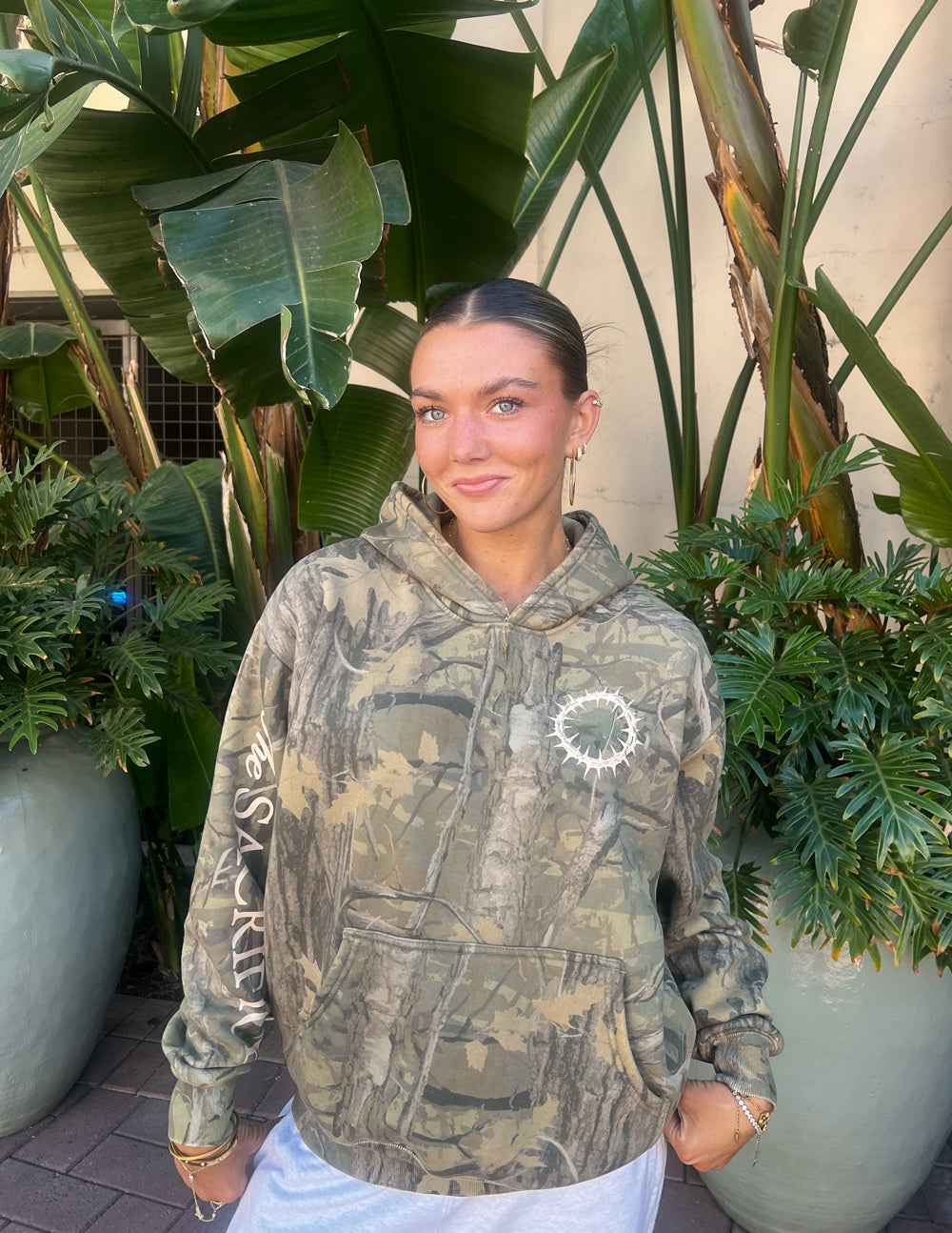 The Sacrifice Camo Hoodie unisex forest camo garment dyed hoodie with 1 Corinthians 15:55 scripture design