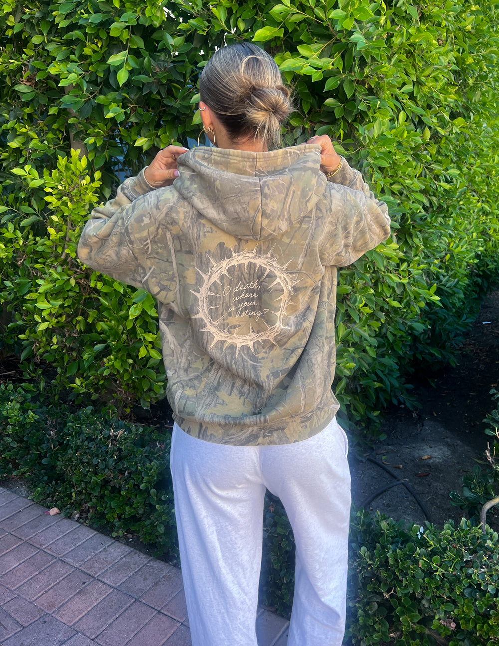 The Sacrifice Camo Hoodie unisex forest camo garment dyed soft cotton blend sweatshirt with 1 Corinthians 15:55 scripture design