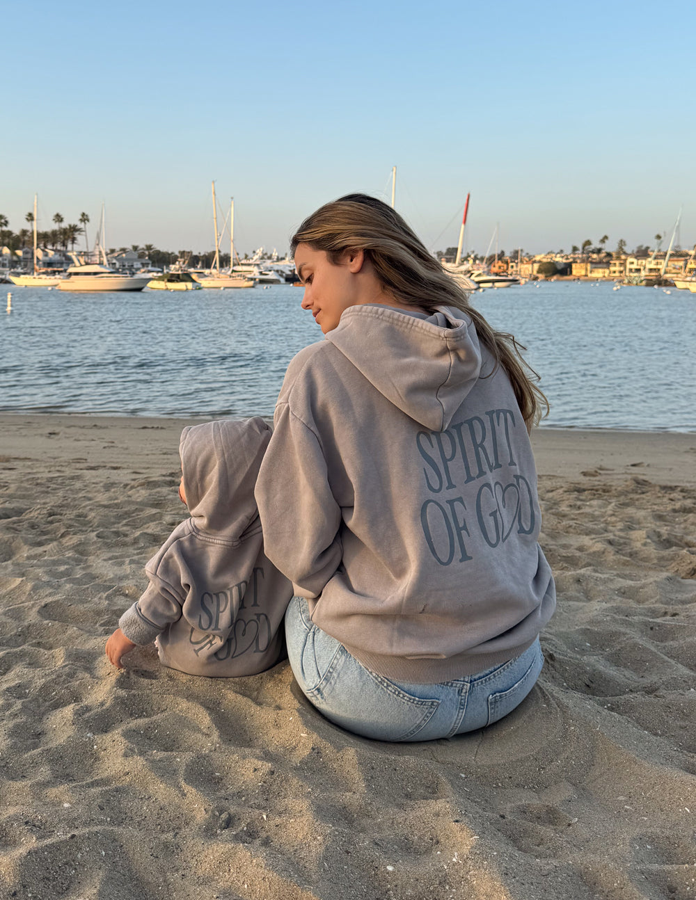 Child wearing Spirit of God kids hoodie in oversized fit and echo color, soft fabric with scripture design